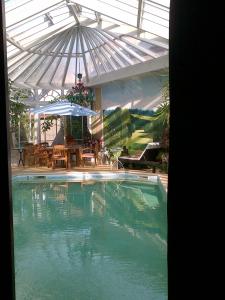 布爾日的住宿－聖博內劇院酒店，一个带遮阳伞和庭院的大型游泳池