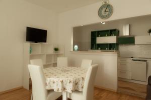 kuchnia i jadalnia ze stołem i krzesłami w obiekcie Holiday Home Domi w Novim Vinodolskim