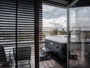 een balkon met een bed, een tafel en een raam bij The Loft Hotel Adults Only in Krakau