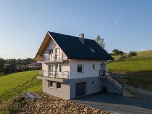 una casa blanca con techo negro en una colina en Dom nad Uhercami en Uherce Mineralne