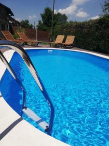 a large blue swimming pool with two chairs next to it at Apartments Franka in Samobor