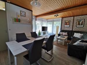 a living room with a table and chairs and a couch at Ferienhaus Rhode am Alfsee in Rieste