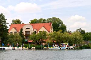 a house with boats docked in front of the water at Hotel Barlinek in Barlinek