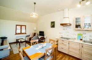 a kitchen and living room with a table and chairs at Apartamenty Romanowka in Raszów