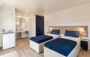 a hotel room with two beds and a kitchen at Camping Village Roma Capitol in Ostia Antica +90 photos