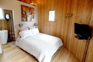 a bedroom with a white bed and a television at Coup 2 Foudres in Saint-Jean-de-Blaignac