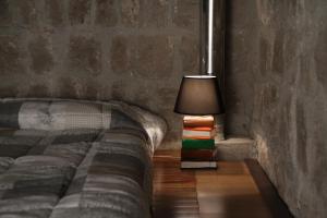 ein Schlafzimmer mit einem Bett mit einer Lampe und Büchern in der Unterkunft Al Libro Letto in Viterbo