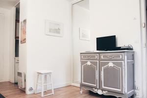 um armário de prata com um portátil em cima dele num quarto em Levis Charming Place em Paris