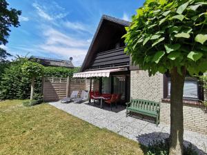 una casa con un banco verde en un patio en Ferienhaus Rhode am Alfsee, en Rieste