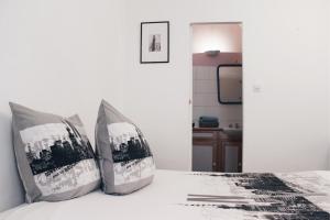 um quarto com uma cama com duas almofadas em Levis Charming Place em Paris