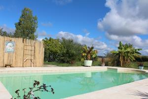 a swimming pool in a yard with a wooden fence at Gîte à la ferme avec piscine in Urgosse