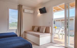a bedroom with a bed and a balcony with a table at Camping Village Roma Capitol in Lido di Ostia