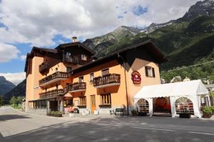 un grande edificio con una tenda bianca di fronte ad esso di Albergo Del Ponte a Baceno