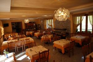 a restaurant with tables and chairs and a chandelier at Albergo Del Ponte in Baceno