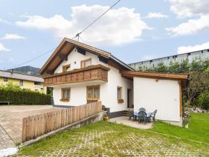 a small white house with a wooden roof at Apartment in Tr polach Carinthia with pool in Tröpolach