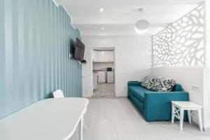VIP Apartment في إلفيف: غرفة معيشة مع أريكة زرقاء وطاولة