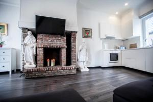 a living room with a brick fireplace with a tv at Luxury Suites Cathedral in Antwerp