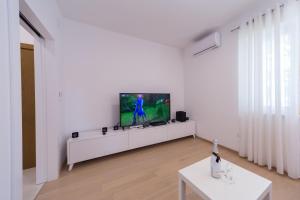 a living room with a tv on a white wall at A&J deluxe apartment in Biograd na Moru