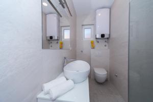 a white bathroom with a toilet and a sink at A&J deluxe apartment in Biograd na Moru +21 photos