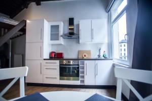 een keuken met witte kasten en een fornuis met oven bij Luxury Suites Cathedral in Antwerpen