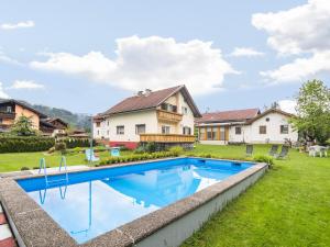 a backyard with a swimming pool and a house at Beautiful apartment with swimming pool in Tröpolach