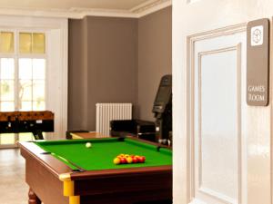
a living room with a pool table and chairs at YHA Stratford-Upon-Avon in Stratford-upon-Avon
