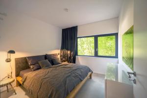 een slaapkamer met een bed en een raam bij Architektur Ferienhaus Eifel SUITE17 in Bad Münstereifel