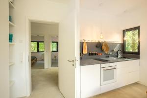 een keuken met witte kasten en een wastafel bij Architektur Ferienhaus Eifel SUITE17 in Bad Münstereifel