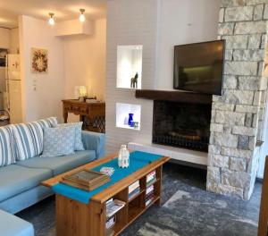 a living room with a blue couch and a fireplace at Hydra's View in Hydra