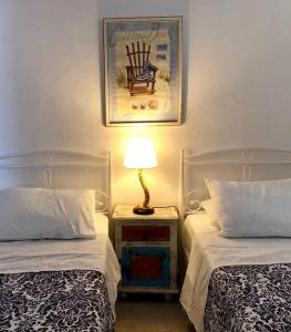 a bedroom with two beds and a lamp on a night stand at Hydra's View in Hydra
