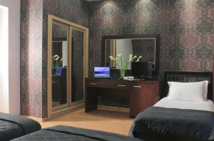 - une chambre avec un bureau, un ordinateur portable et un miroir dans l'établissement Galaxy Art Hotel, à Oraiokastro