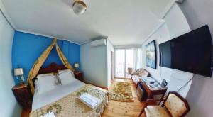 - une chambre avec un grand lit et une télévision dans l'établissement Hotel Risco, à Laredo