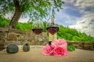 twee glazen wijn en een roze bloem op een tafel bij Casa Al Bosco in SantʼEllero
