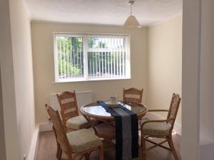 a dining room with a table and chairs and a window at Hooton Golf Club in Little Sutton