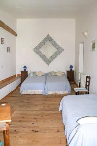 a bedroom with two beds and a wooden floor at DOMAINE DE MARLAS - CHAMBRES D'HÔTES in Rieucros