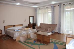 ein Schlafzimmer mit einem Bett, einem Sofa und einem Tisch in der Unterkunft Tri Korony in Tscholponata