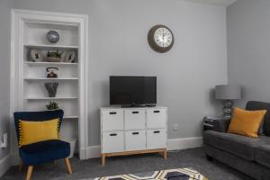 a living room with a tv on a white cabinet at The Old Post House in Kyle of Lochalsh