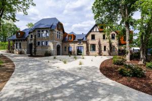 a large stone house with a driveway at Domaine de Ronchinne - Maison du Jardinier in Maillen