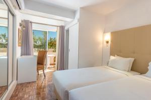 a hotel room with two beds and a view of the ocean at Vila Channa - Adults Only in Albufeira +121 photos