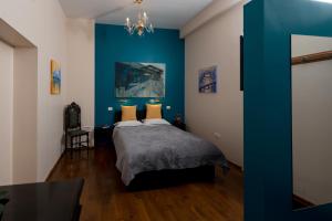 Un dormitorio con una pared de acento azul y una cama en Casa Miron 1 en Timisoara
