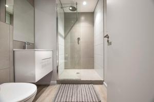 a bathroom with a shower with a toilet and a sink at C502 Woodstock Quarter in Cape Town +10 photos