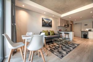 a living room with a couch and a table and chairs at C502 Woodstock Quarter in Cape Town
