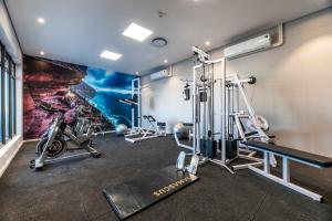 a gym with tread machines and a wall mural at C502 Woodstock Quarter in Cape Town