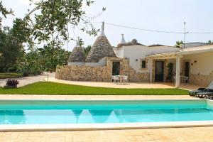 a villa with a swimming pool in front of a house at Residence Spadalunga in San Michele Salentino