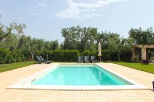 uma piscina com duas cadeiras e uma mesa em Residence Spadalunga em San Michele Salentino