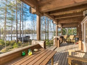 een houten terras met een tafel en stoelen erop bij Holiday Home Pirttiniemi by Interhome in Kangasniemi