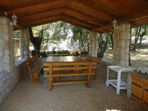 un patio con tavolo e sedie sotto un tetto di Apartments Barbara a Pinezići