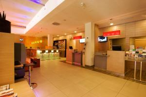 a fast food restaurant with a waiting room and a counter at Ibis Wien Messe in Vienna