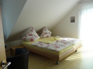 a small bed with pillows on it in a room at Haus Erika Am Weg in Kesswil