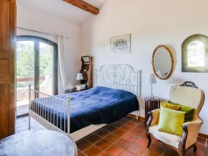 um quarto com uma cama, uma cadeira e um espelho em Villa Les Baux Rouges by Interhome em Solliès-Ville